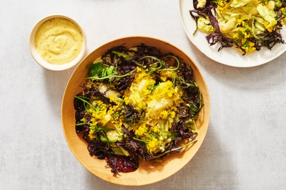 Two plates of Potato-Mustard Greens Fritters and Salad topped with vibrant yellow mustard