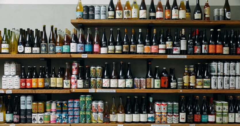 A full open shelf of various ciders